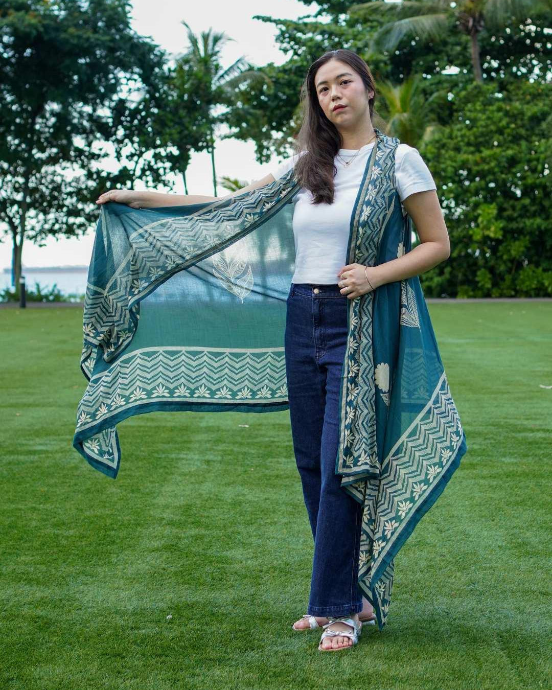 Indigo floral kimono in sustainable cotton, draped over shoulder, paired with white top and navy jeans, women's casual wear.