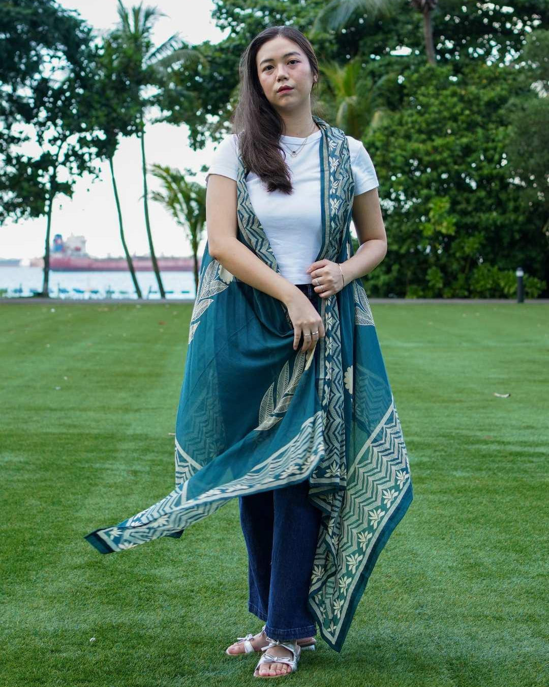 Indigo floral kimono in sustainable cotton, sleeveless, flowing design, styled over casual white top and jeans for women.