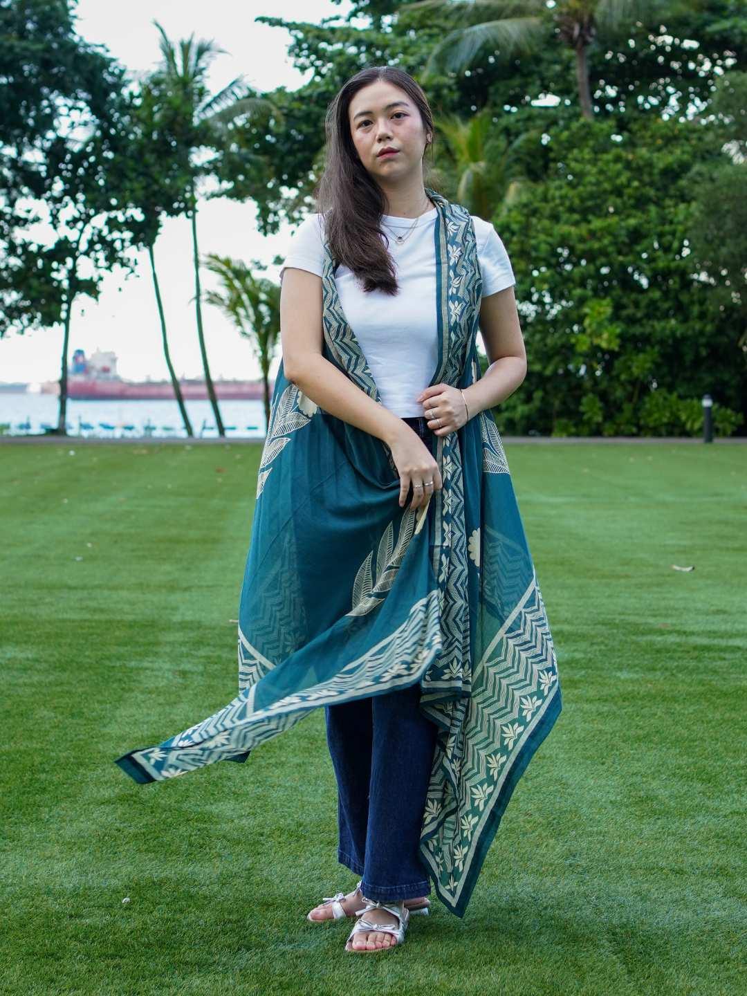 Indigo floral kimono in sustainable cotton, sleeveless, flowing design, styled over casual white top and jeans for women.