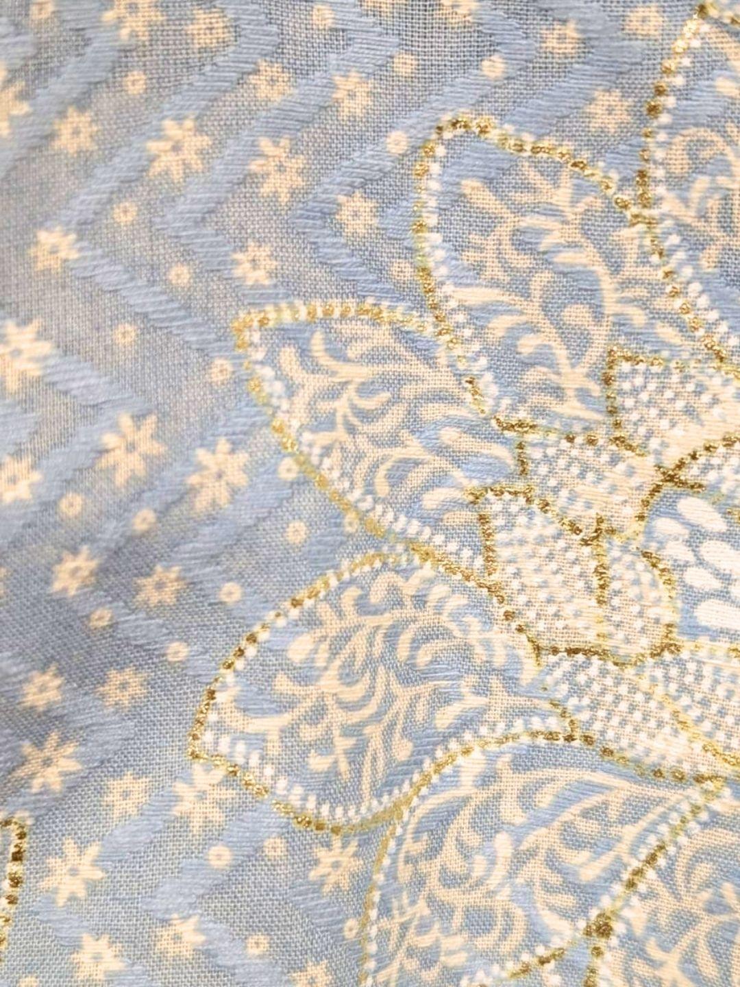 Close-up of blue cotton kurta fabric with intricate cream and gold floral embroidery and tiny scattered motifs. - Nimbu