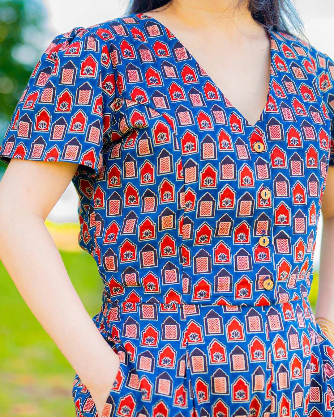 Royal blue and maroon sustainable cotton jumpsuit with short sleeves and V-neck, featuring a fitted waist and casual style.