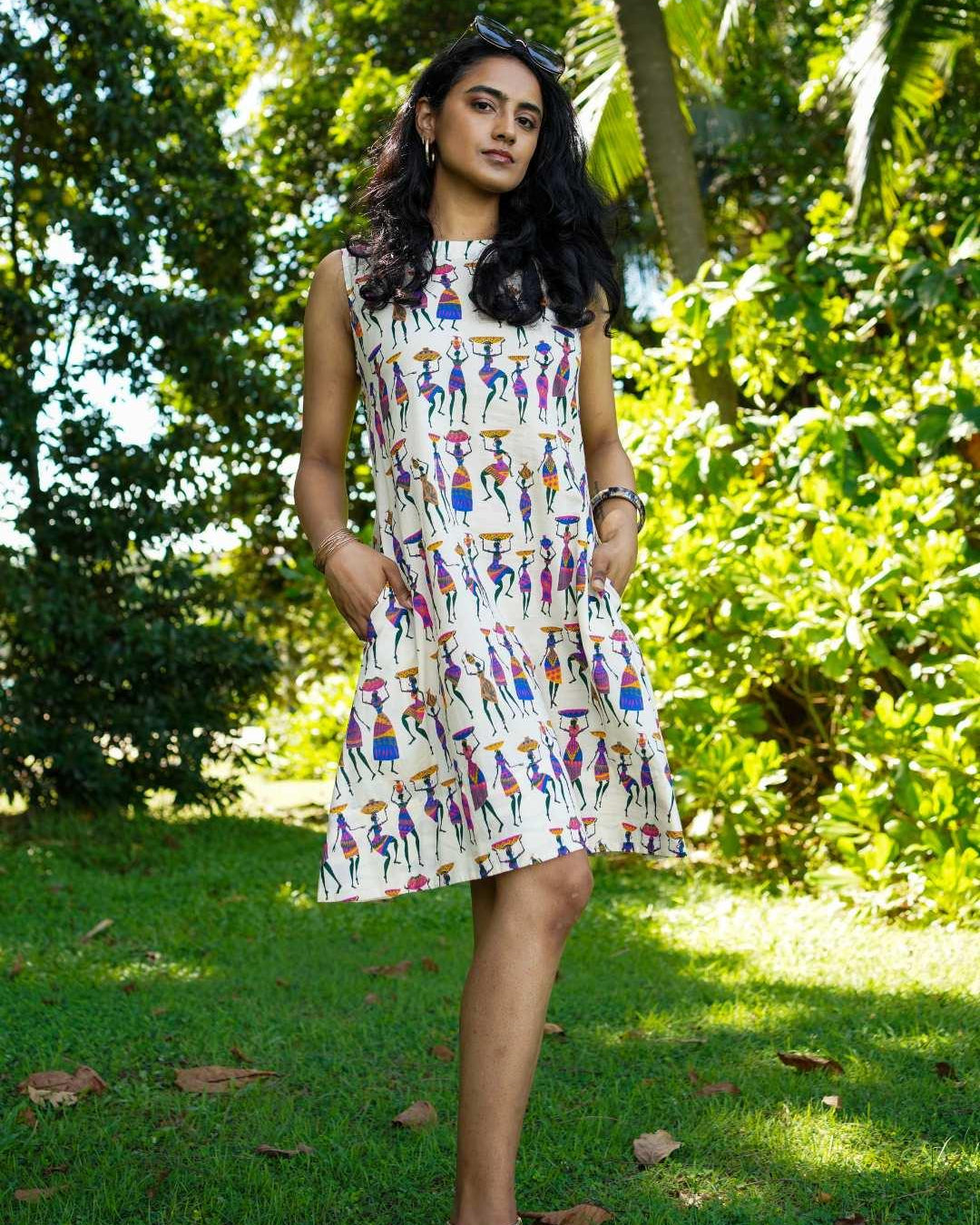 Sleeveless A-line women's dress in cotton with colorful folk story print, sustainable and casual style.