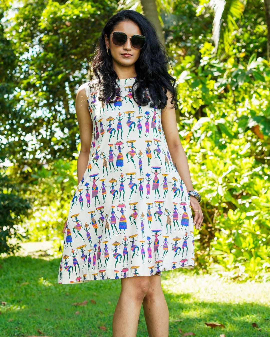 Azure sustainable cotton womenβs A-line dress with colorful folk story print and cap sleeves.