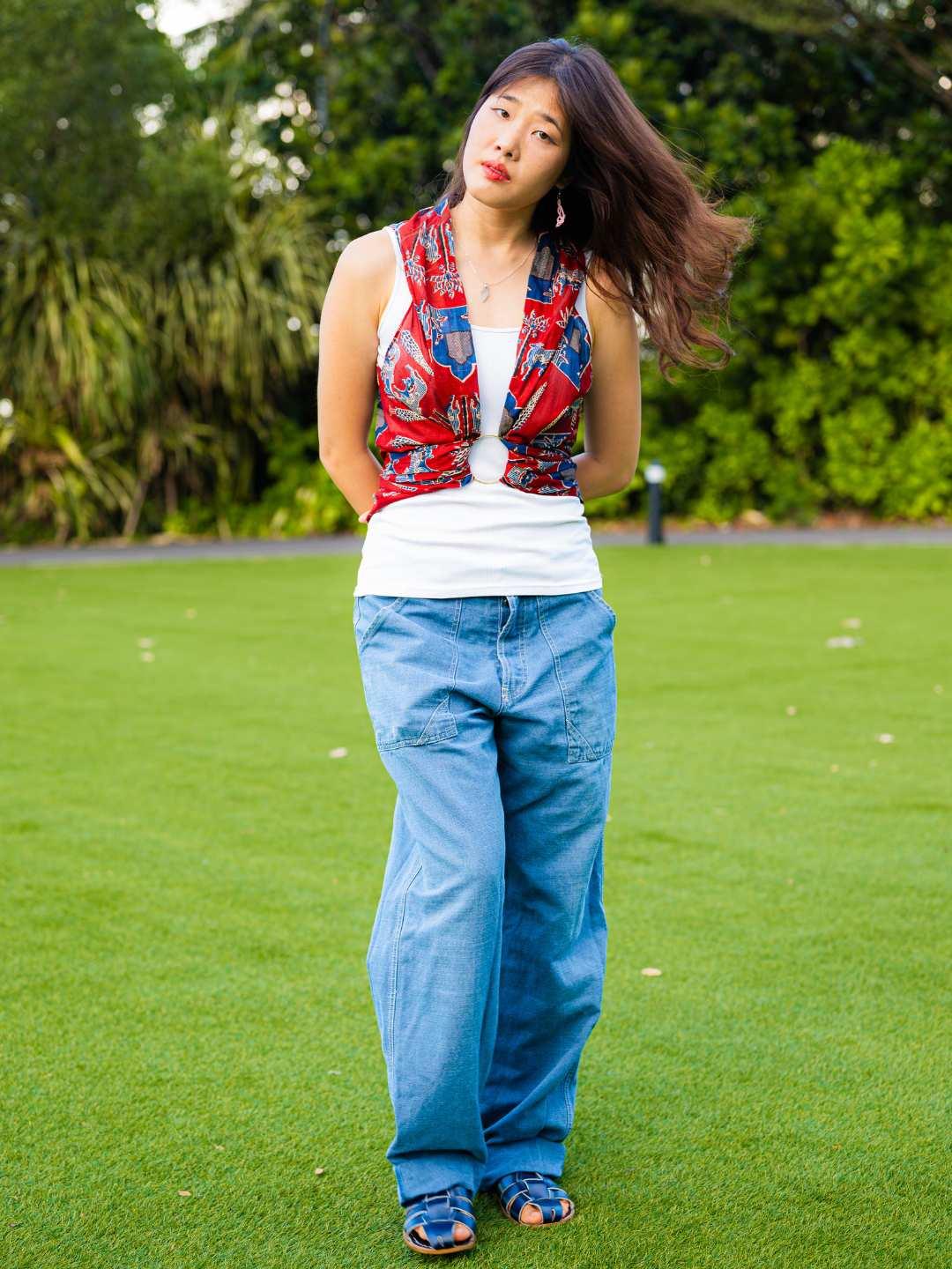 Royal maroon sustainable cotton kimono with sleeveless, open front design on woman wearing casual blue pants.