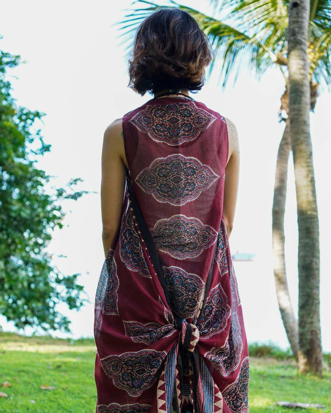 Vintage maroon cotton kimono with intricate patterns, sleeveless design, and tie-back detail in a sustainable fabric.