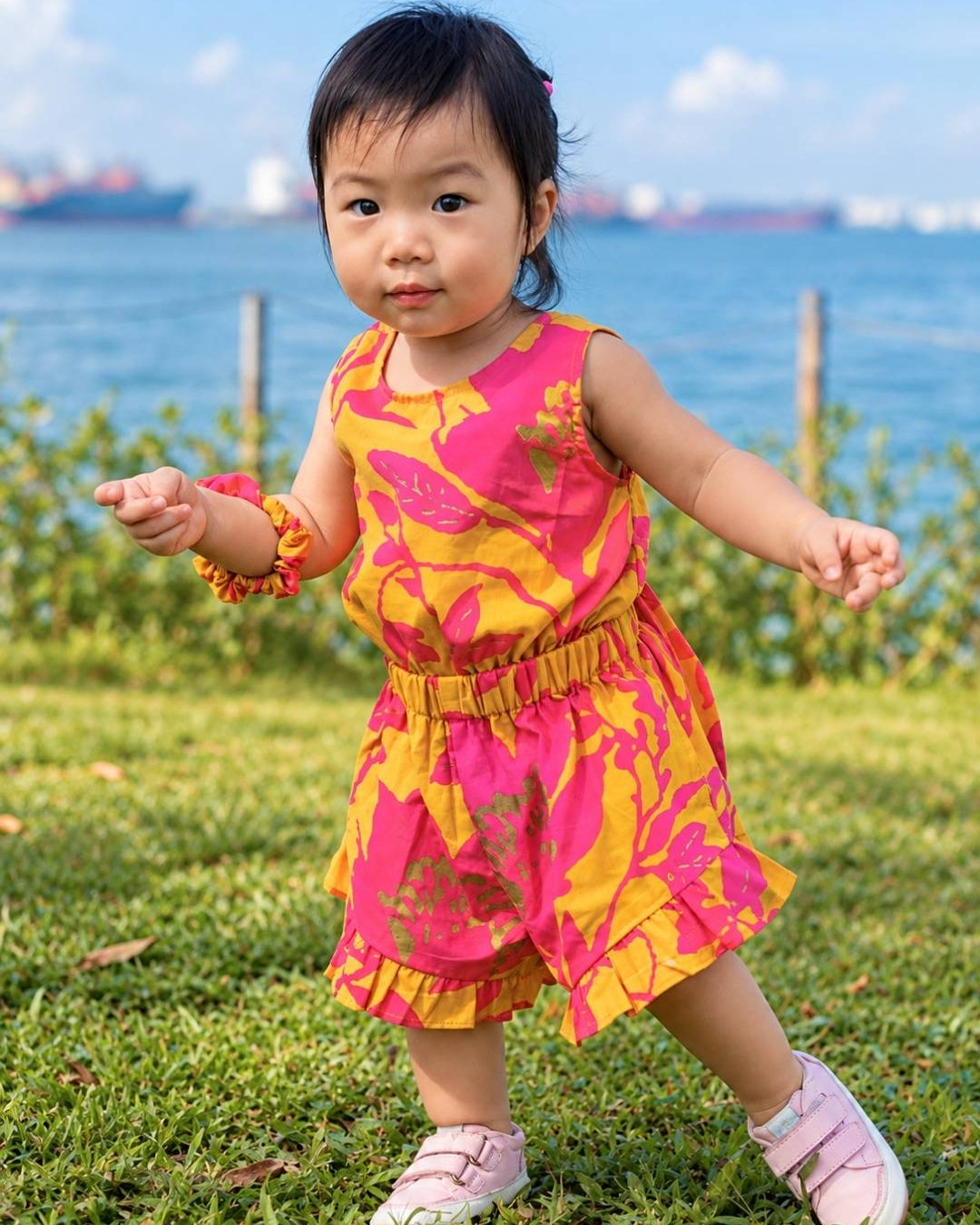 Girls mustard and hot pink cotton playsuit with floral print, sleeveless design, and elastic waist, toddler size,.
