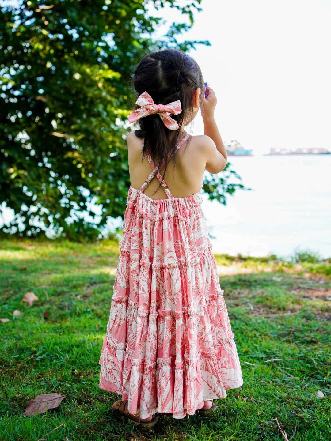 Girl’s long, sleeveless pink floral cotton dress with tiered skirt, sustainable fabric, toddler size.