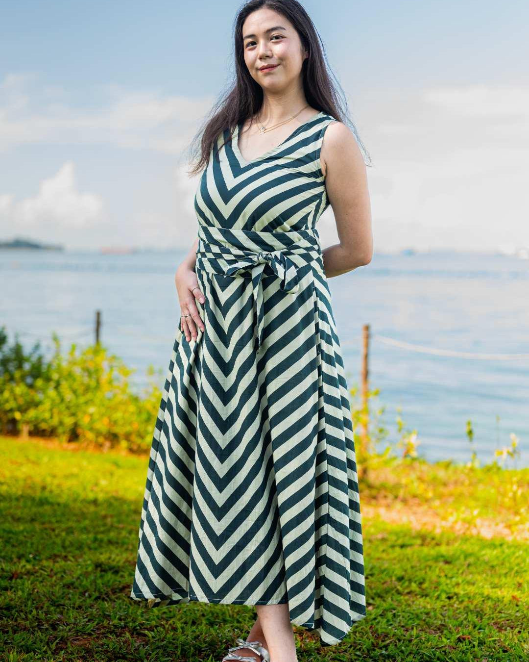 Green and white striped sleeveless cotton dress with obi belt, sustainable fabric, casual women’s style.