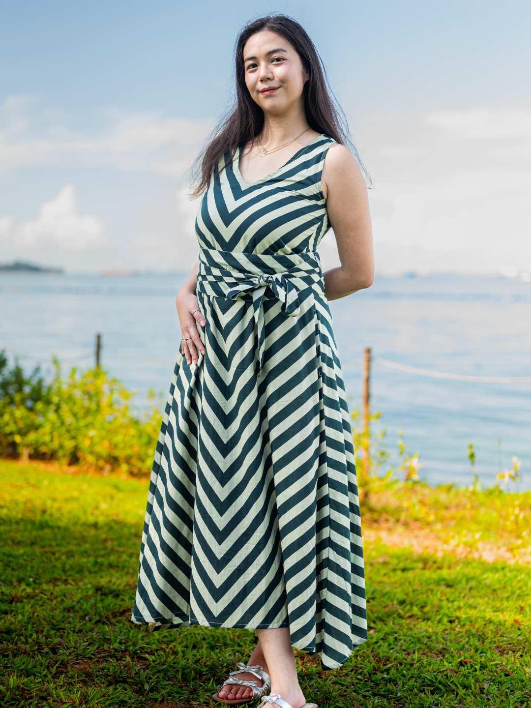 Green and white striped sleeveless cotton dress with obi belt, sustainable fabric, casual women’s style.