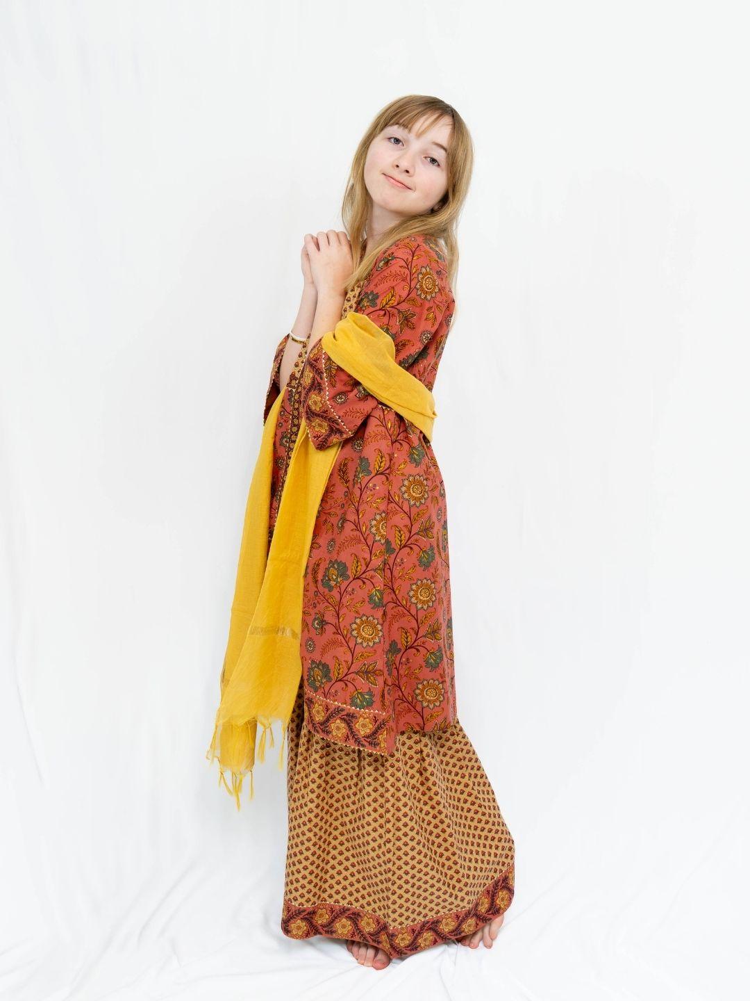 Girls’ coral and gold cotton kurti sharara set with an allover floral print and yellow dupatta. - Nimbu
