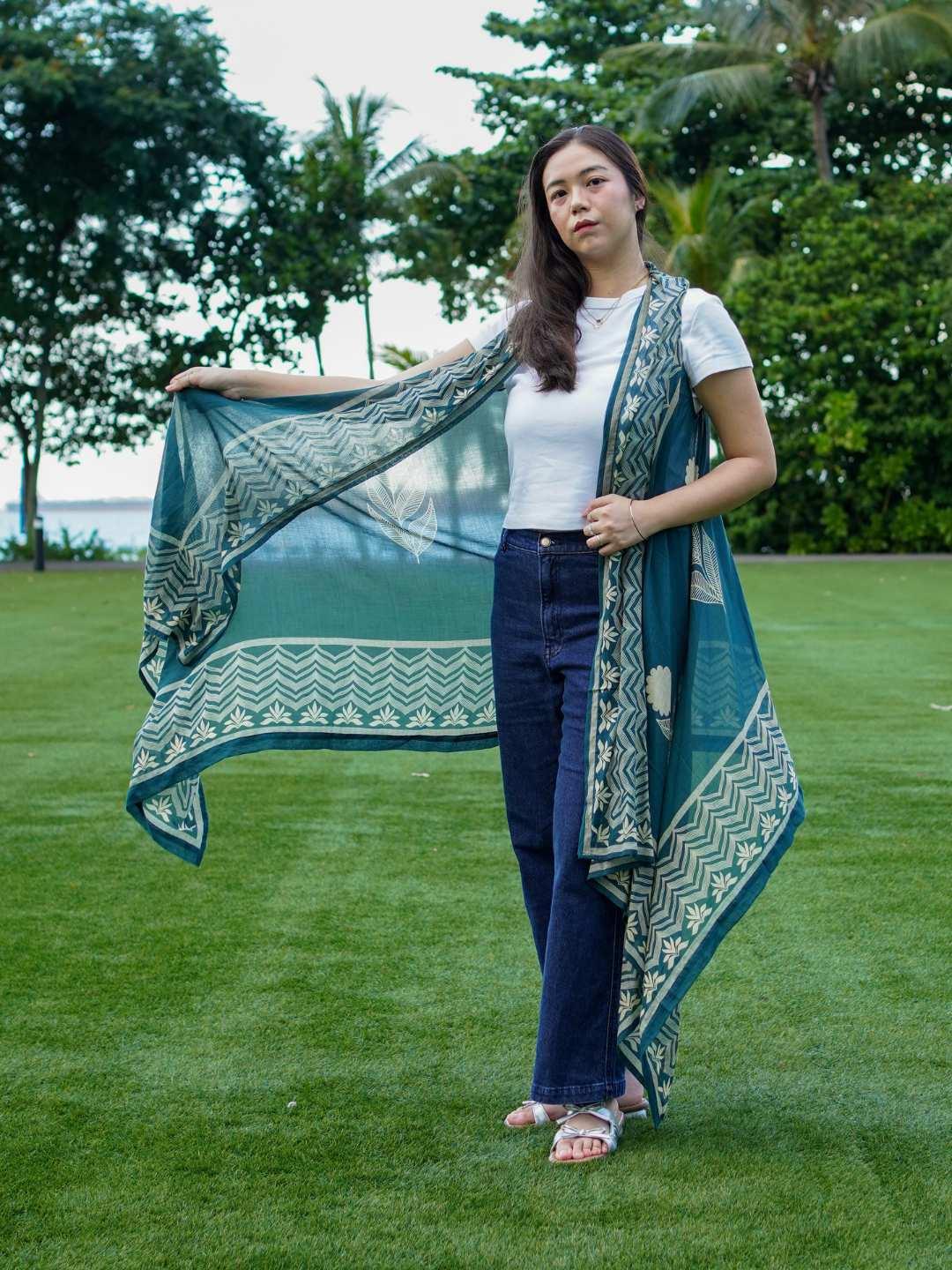 Indigo floral kimono in sustainable cotton, draped over shoulder, paired with white top and navy jeans, women's casual wear.