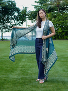 Indigo floral kimono in sustainable cotton, draped over shoulder, paired with white top and navy jeans, women's casual wear.