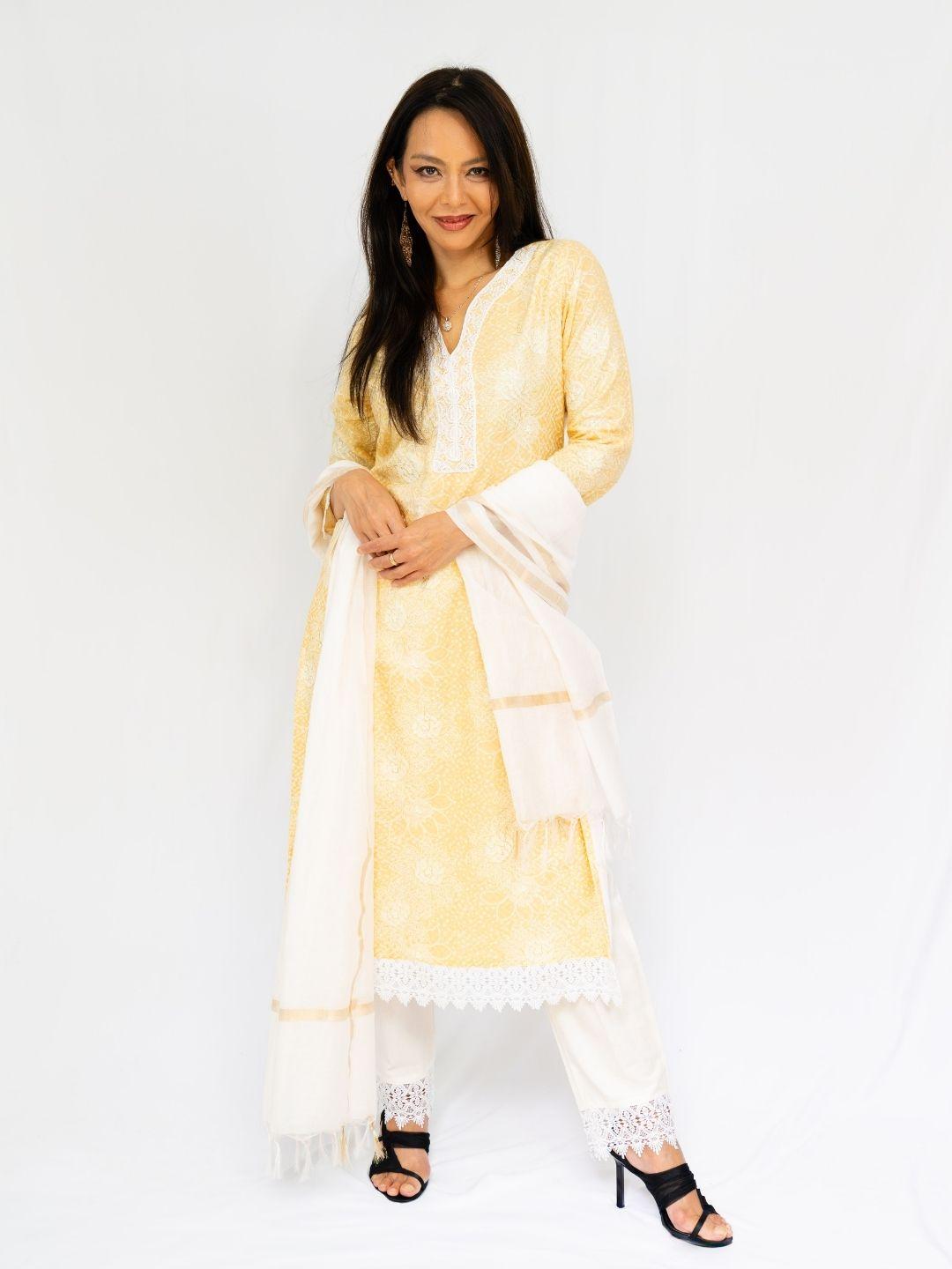 Women’s pale yellow embroidered kurti with matching pants and dupatta, finished with delicate white lace trim. - Nimbu