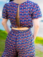 Women’s royal blue and maroon cotton jumpsuit with short sleeves and keyhole back, sustainable design.