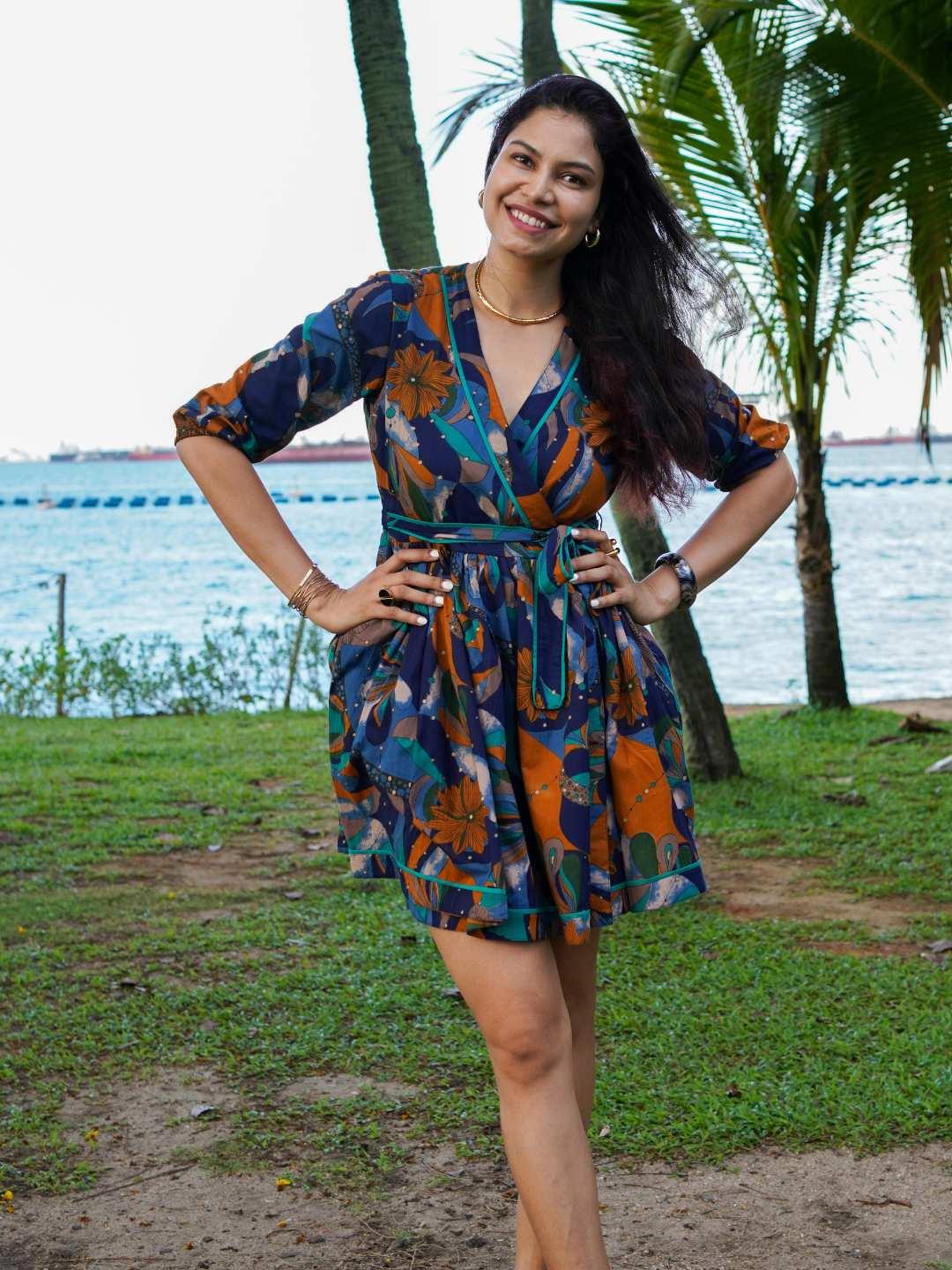 Women's short dress in blue and orange mosaic print, sustainable cotton with a wrap-style waist and elbow sleeves.
