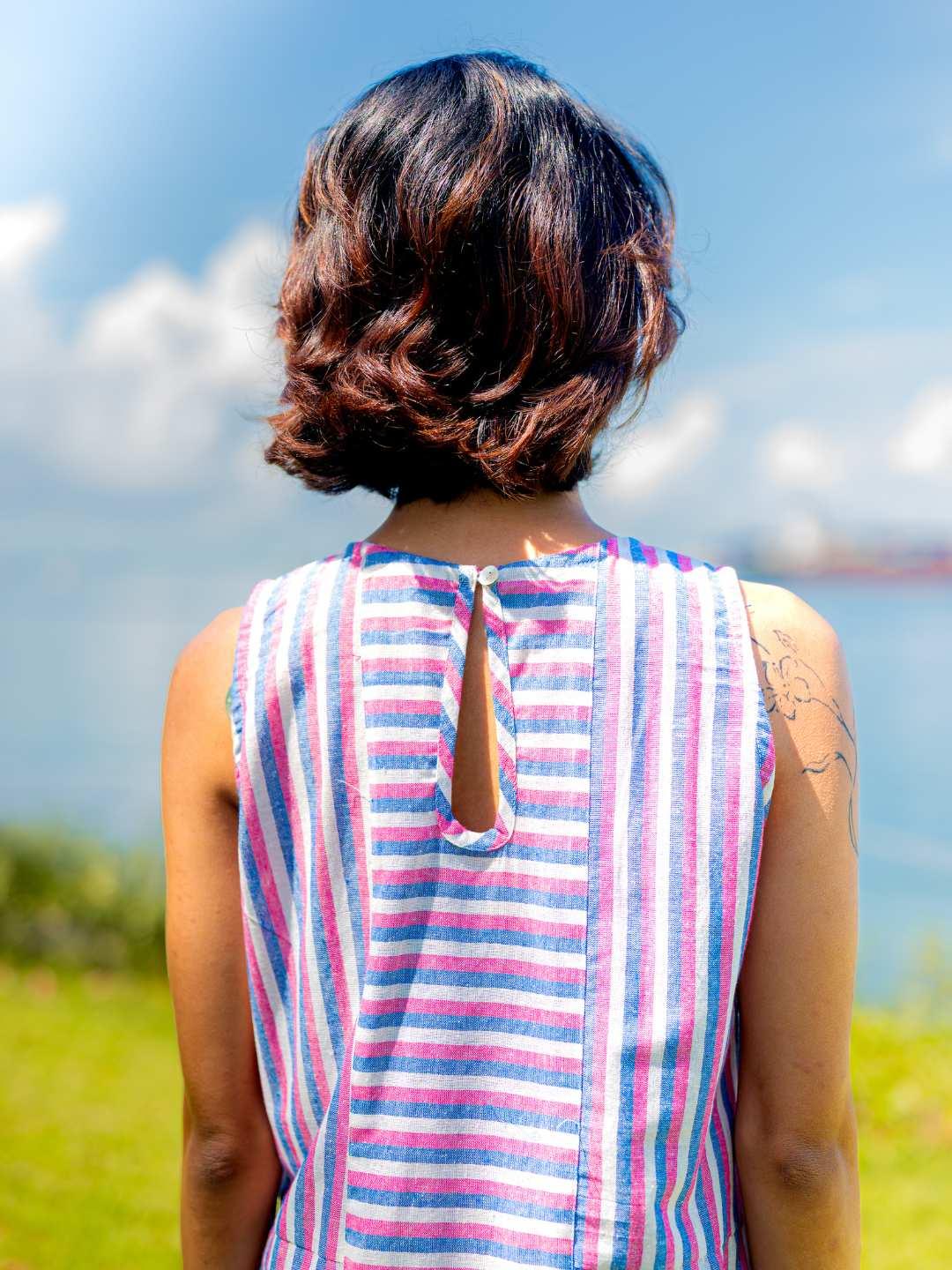Sleeveless Luna women's cotton dress with blue and pink stripes, back slit and keyhole detail, sustainable fabric.