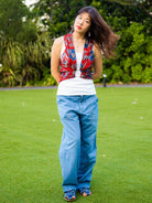 Royal maroon sustainable cotton kimono with sleeveless, open front design on woman wearing casual blue pants.