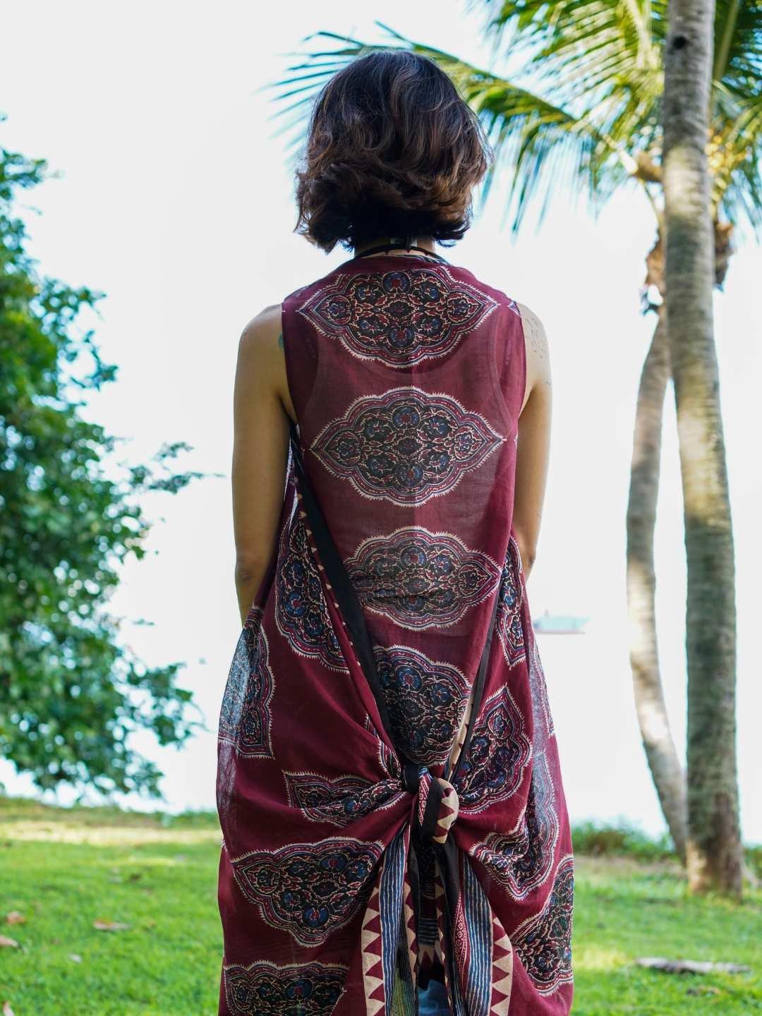 Vintage maroon cotton kimono with intricate patterns, sleeveless design, and tie-back detail in a sustainable fabric.