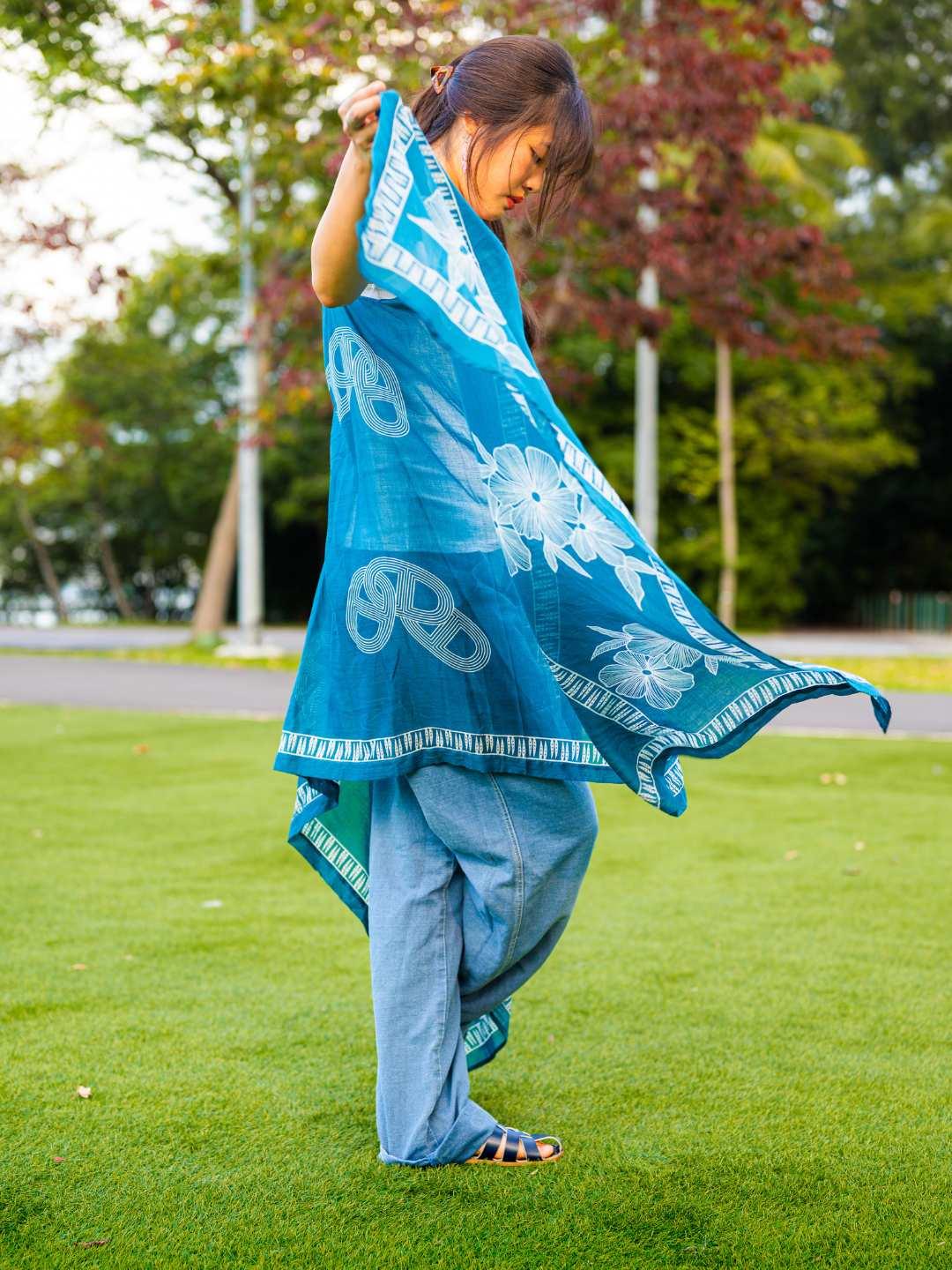 Indigo cotton kimono with white pretzel pattern, sustainable fabric, worn over casual blue pants.