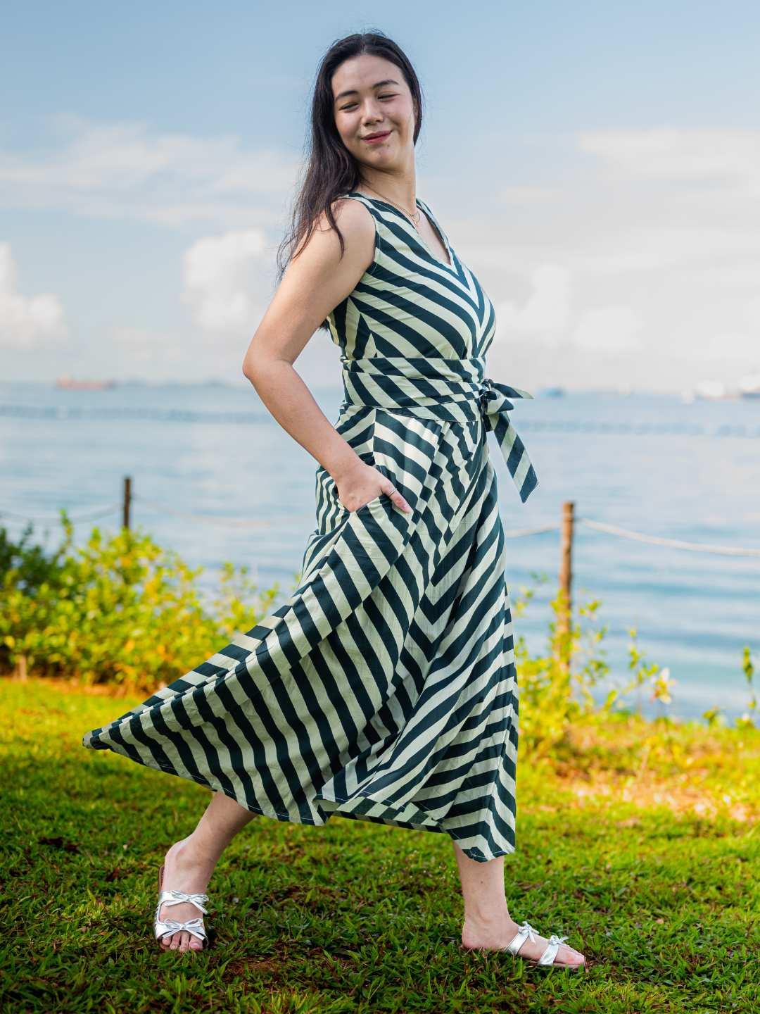 Green and white striped sustainable cotton women’s midi dress with obi belt and side pockets.