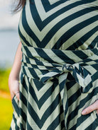 Green cotton dress with black chevron stripes and a tied obi belt, sustainable fabric, women's casual wear.