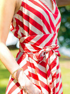Red and white striped sleeveless cotton dress with V-neck and tied obi belt, sustainable fabric, women's casual wear.