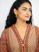 Women’s coral kurti with gold geometric and floral prints, V-neck, button front, and three-quarter sleeves. - Nimbu